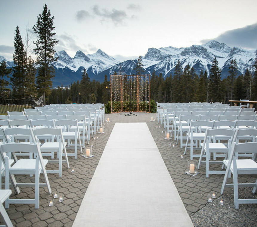 Outdoor wedding with white folding chairs