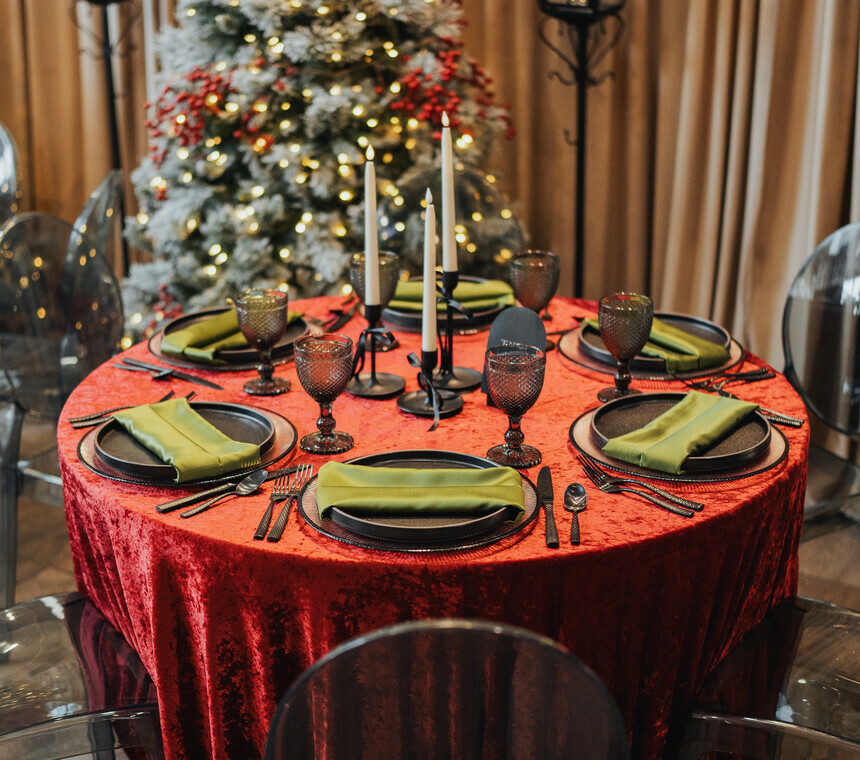 A table setting with christmas decorations, a christmas tree and lamp posts in the background