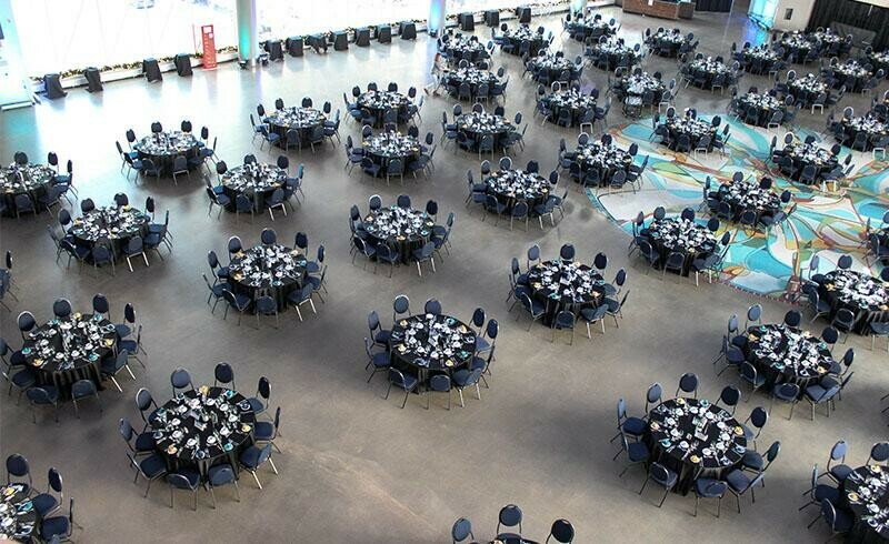 Special Event Rentals - Edmonton renting out over 100 tables, navy banquet chairs, black tablecloth and other tableware for a big corporate event in Rogers Place